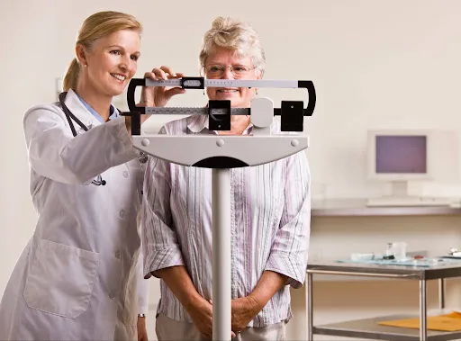 doctor weighing patient on scale